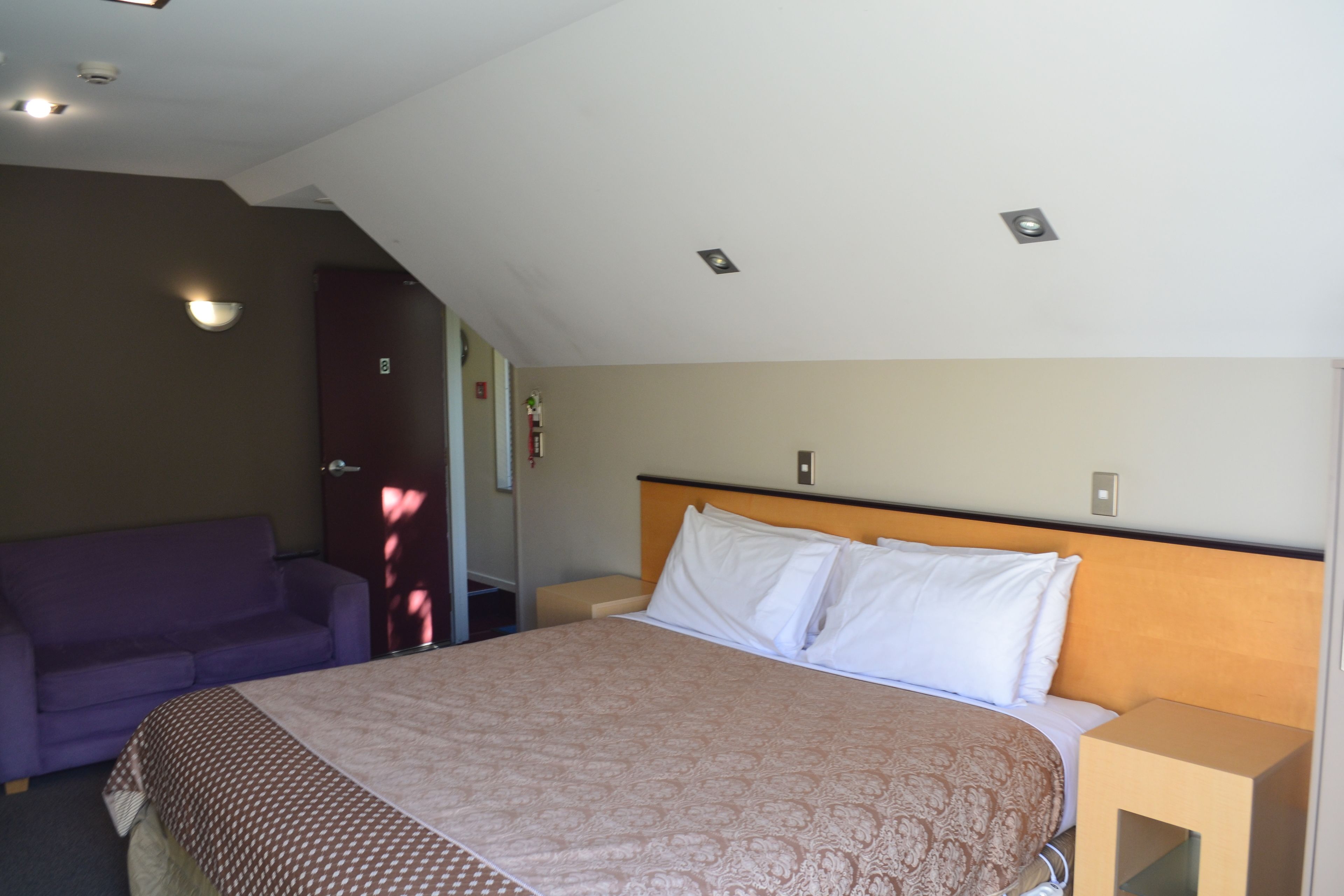 Une chambre d’hôtel avec un lit, un canapé et une table de chevet.
