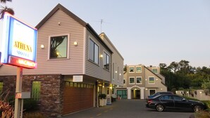 Un motel con un letrero que dice "ATHENA MOTEL" y un letrero que indica "Banda Ancha de Alta Velocidad".