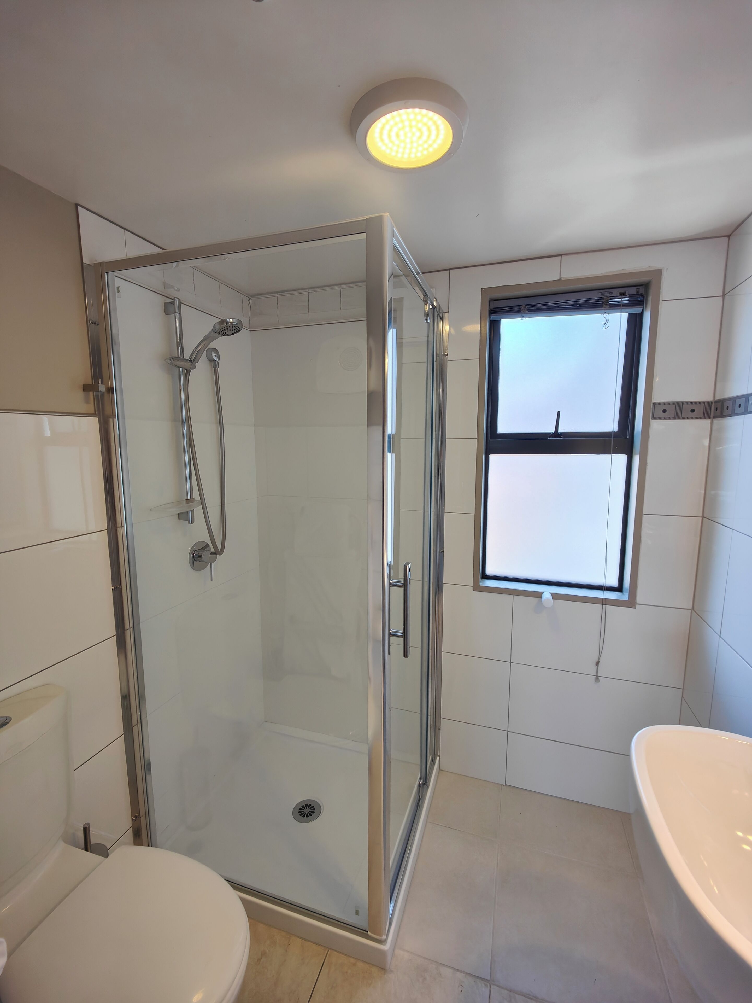 Ein modernes Badezimmer mit einer Duschkabine, einer Toilette und einer Badewanne.