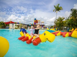 Una piscina al aire libre, sombrillas, sillones reclinables de piscina