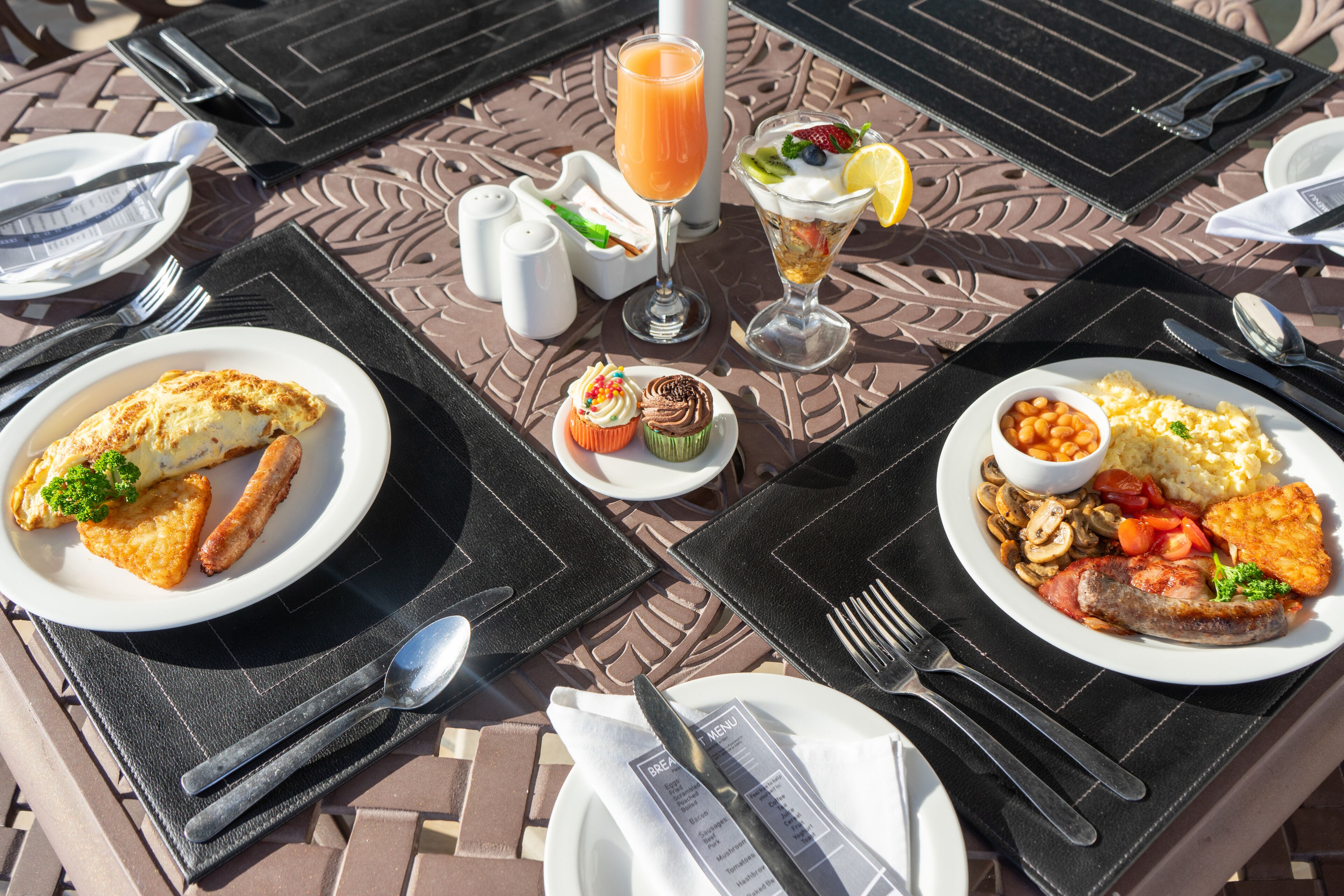 Une table mise pour un repas, avec des assiettes remplies de nourriture, des couverts et un menu.