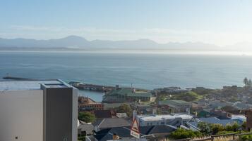 A coastal town with a view of the sea and mountains in the distance.