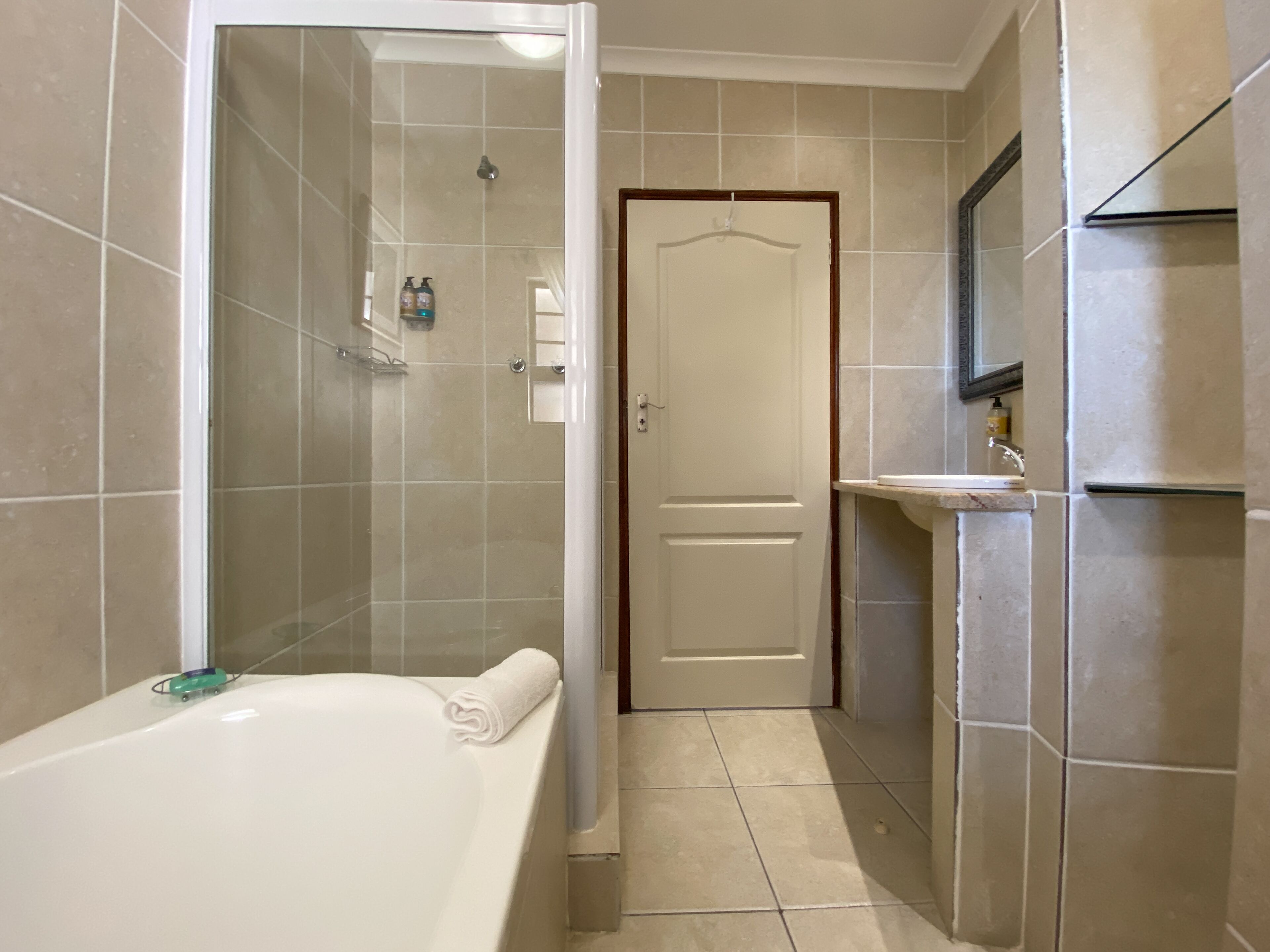 Een badkamer met een bad, douche en wastafel.