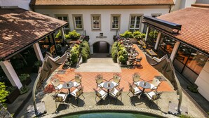 Un patio con mobiliario exterior y una piscina.