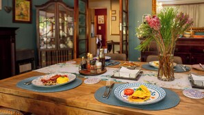 Una mesa de comedor dispuesta con platos, cubiertos y un florero.