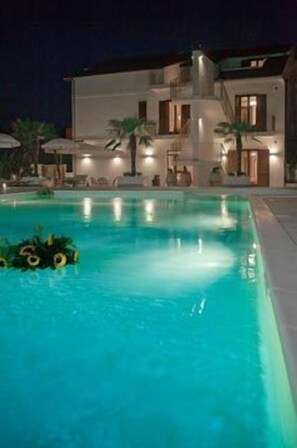 Una piscina con una casa moderna al fondo.