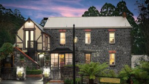 A stone building with a traditional design, featuring a staircase and a sign indicating a 5-minute customer parking area. - The Loft In The Mill Boutique Accommodation (Olinda)