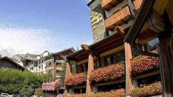 Una fila di edifici in legno con balconi, ognuno decorato con fioriere.