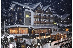 A multi-story hotel with balconies and snow-covered roofs. - Hotel Pavillon (Courmayeur)