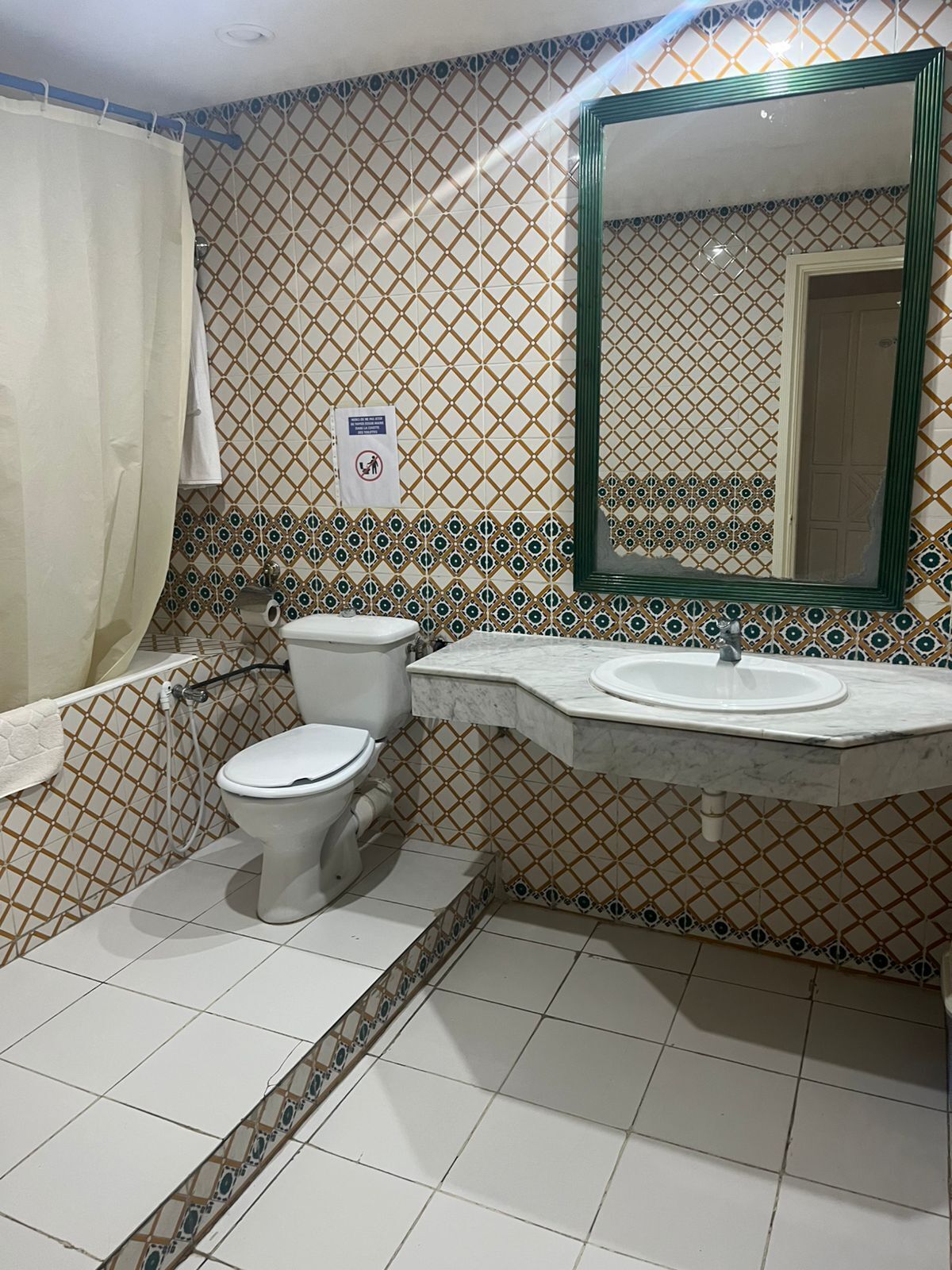 A bathroom with a toilet, sink, and shower.