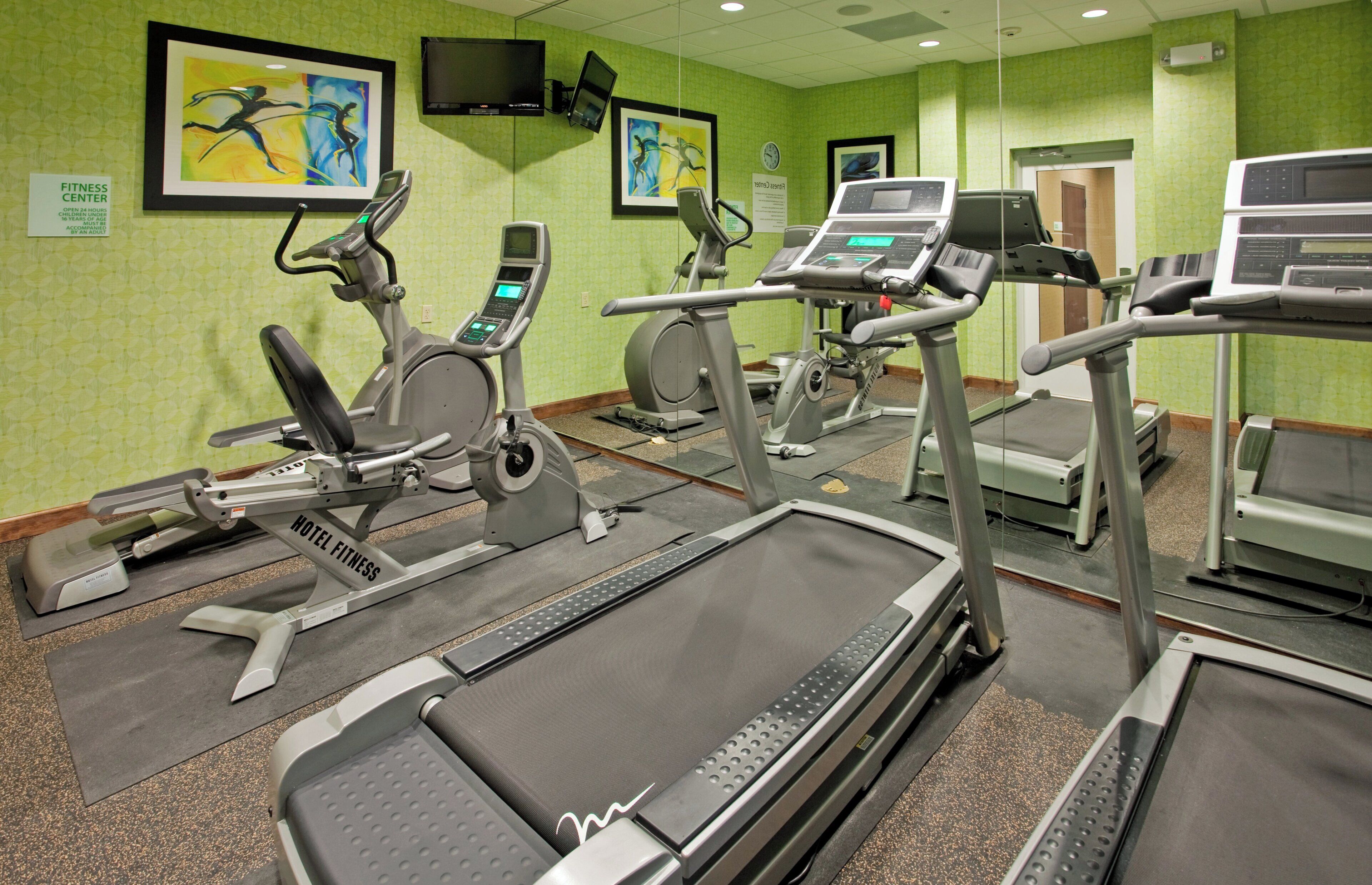 A fitness center with treadmills, elliptical machines, and stationary bikes.
