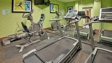 A fitness center with treadmills, elliptical machines, and stationary bikes.