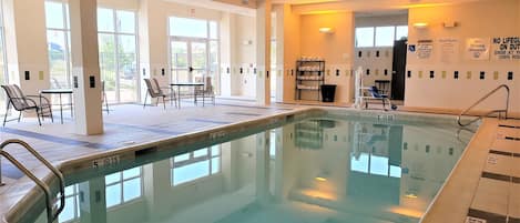 Una piscina interior con agua cristalina, una silla de salvavidas y un letrero que indica que no está permitido bucear.