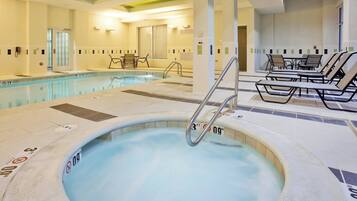Un bain à remous dont la profondeur maximale est indiquée à 3 pieds, une piscine dont la profondeur maximale est indiquée à 5 pieds, et des chaises longues disposées autour de la piscine.