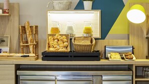 Ein Frühstücksbuffet mit Brot, Gebäck und Getränken.