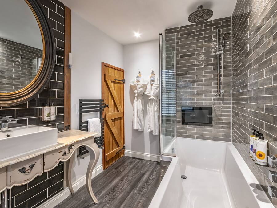 Une salle de bain moderne avec un grand miroir, un lavabo blanc, une baignoire et un espace douche.