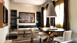 A modern living room with a sofa, a dining table, and a large painting on the wall. - Babuino 181 – Small Luxury Hotels of the World (Rome)