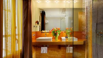 A modern bathroom with two sinks, a mirror, and a shower with a glass enclosure.