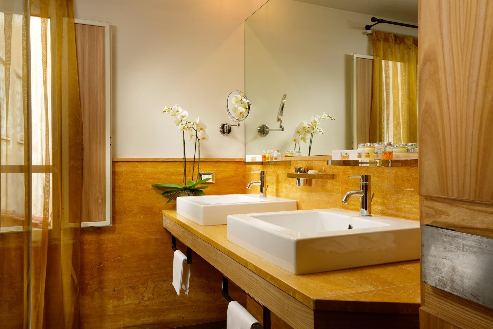 A bathroom with two sinks, a mirror, and a towel rack.