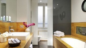 Une salle de bain moderne avec un meuble-lavabo en bois, un grand miroir, une baignoire et un espace douche.