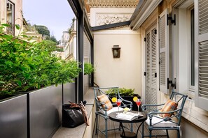 A balcony with two chairs, a table, a magazine, a handbag, and a cocktail glass. - Babuino 181 – Small Luxury Hotels of the World (Rome)