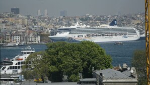 Un grand navire de croisière était amarré dans un port, avec une vue sur la ville en arrière-plan.