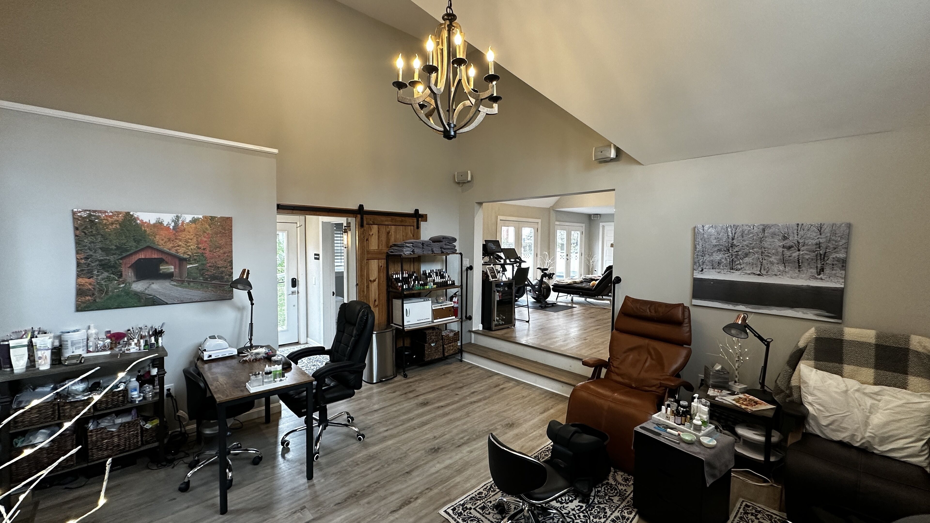 A spacious living room with a dining area, a large chandelier, and a cozy seating area with a fireplace.