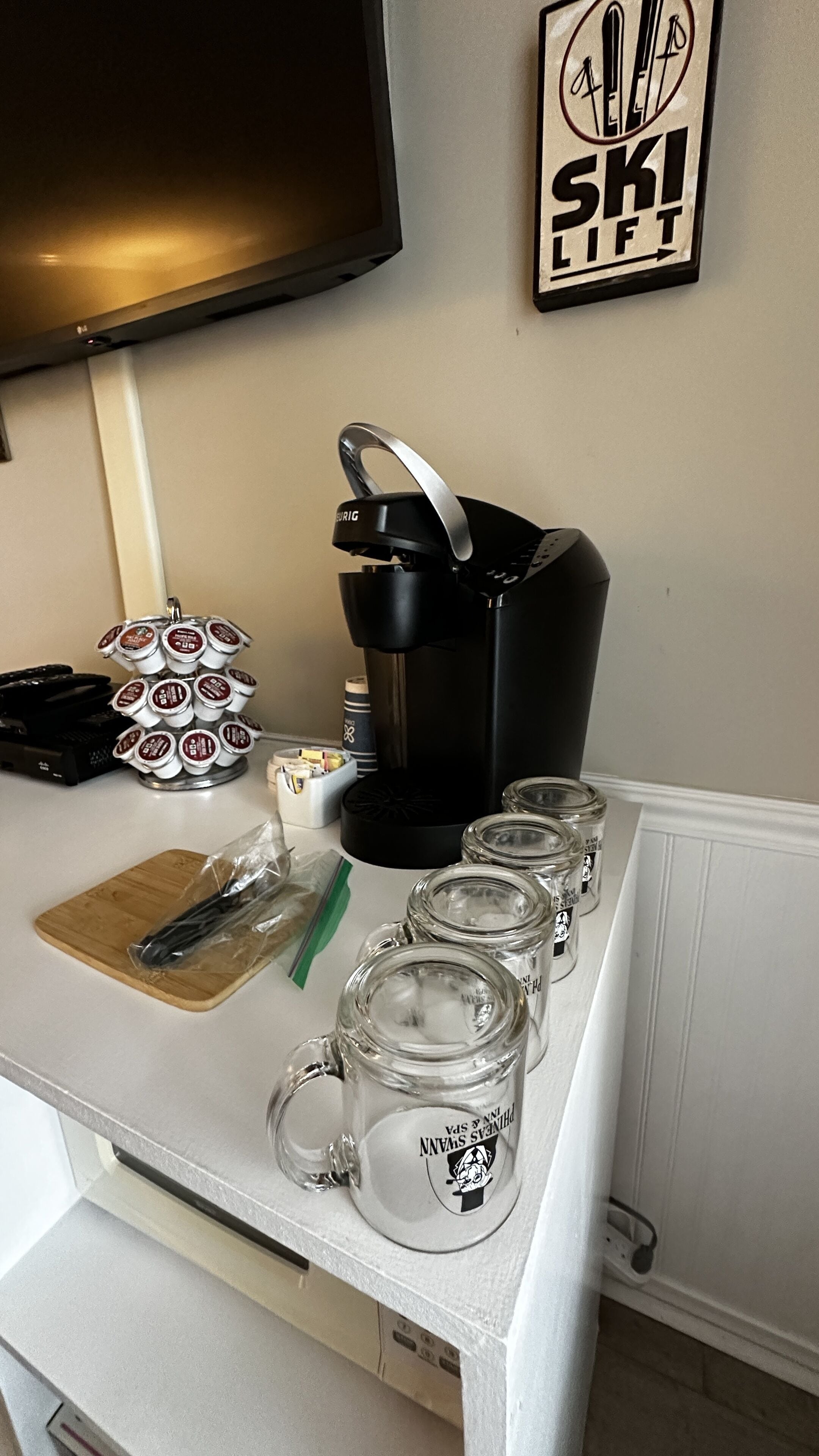 Eine Küchenarbeitsplatte mit einer Kaffeemaschine, einem Becherhalter und einer Ablage mit Besteck.