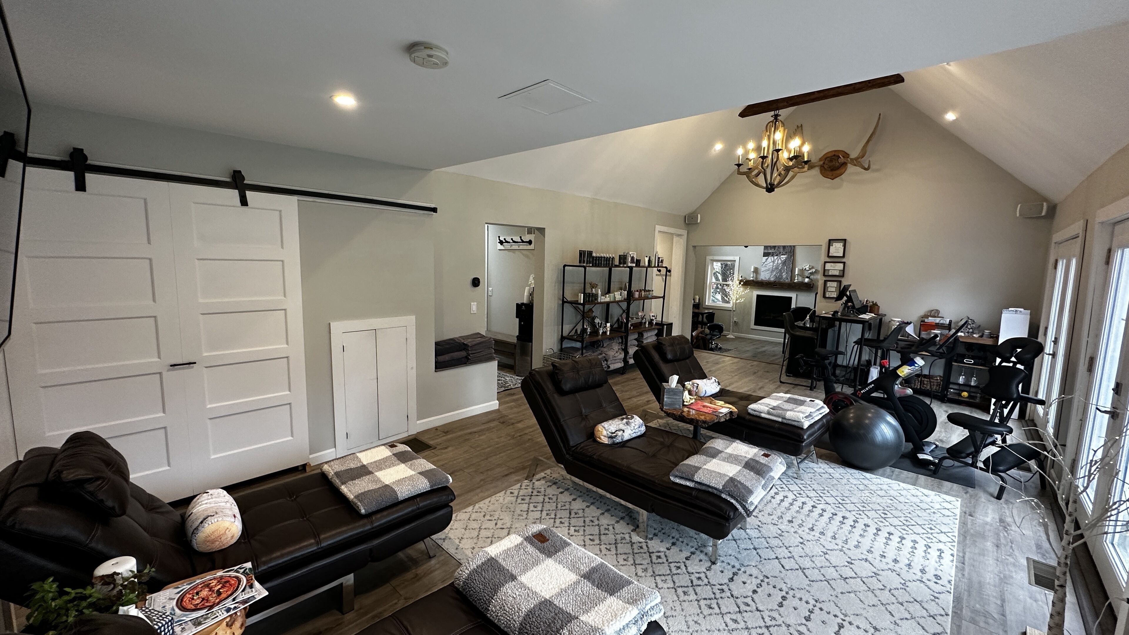 A spacious living room with a large couch, a coffee table, and a fireplace in the background.