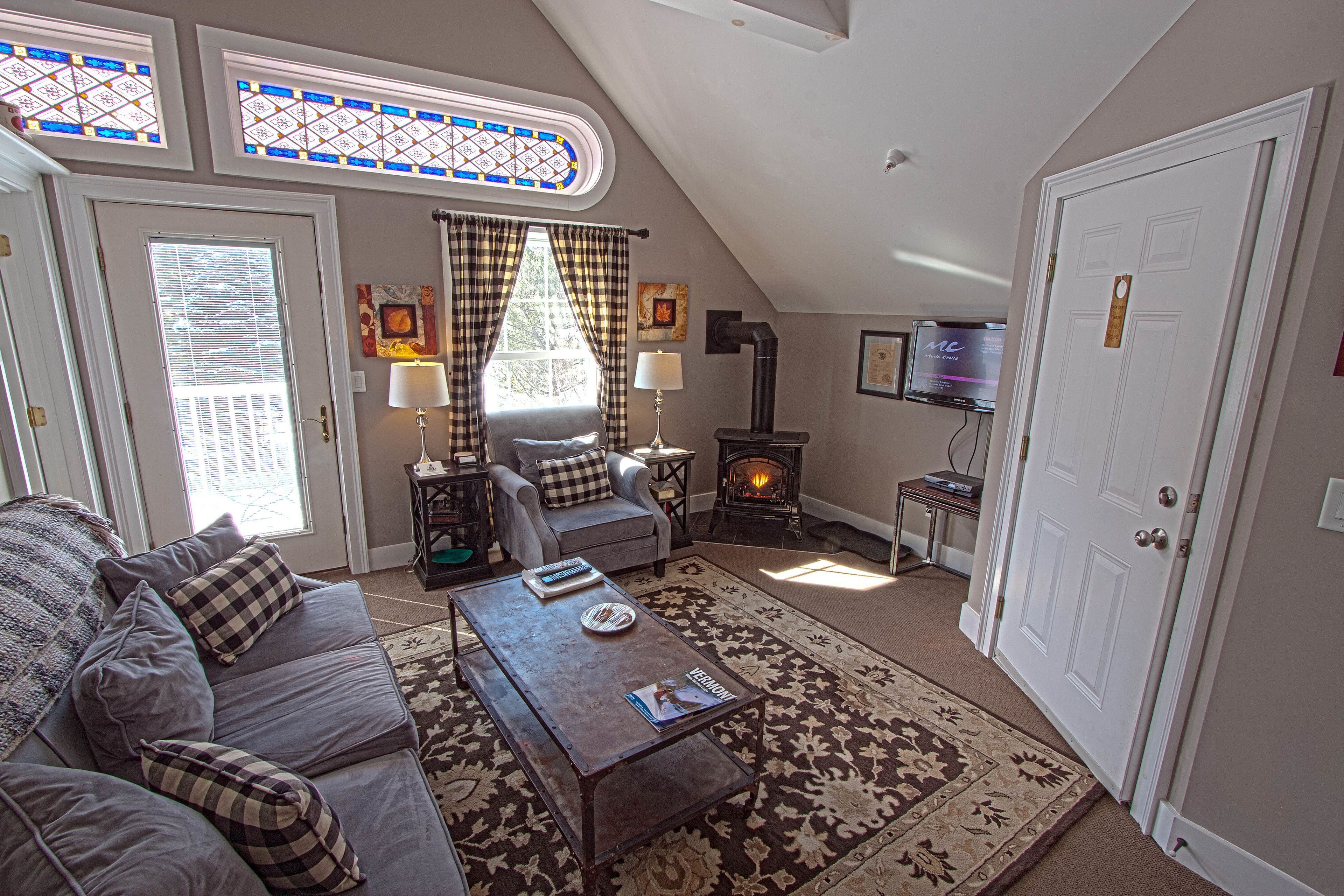 A cozy living room with a fireplace, a sofa, a coffee table, and a television.