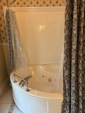 A bathtub with a showerhead, a faucet, and a drain.