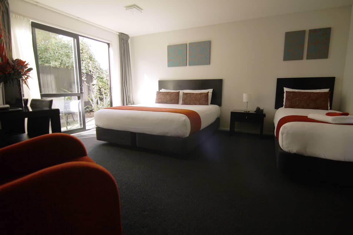Ein Hotelzimmer mit zwei Betten, einem Schreibtisch und einem Stuhl.
