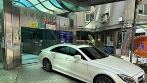 A white car parked in front of a hotel entrance with a sign indicating room numbers B3, B4, and B5. - Hotel HD Palace (Taipei)