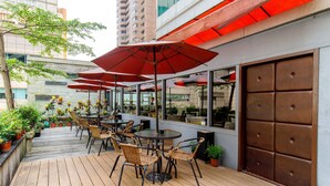A rooftop patio with outdoor seating, potted plants, and a view of the cityscape. - Hotel HD Palace (Taipei)