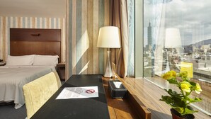 A hotel room with a bed, a desk with a lamp, a window with a city view, and a plant. - Hotel HD Palace (Taipei)