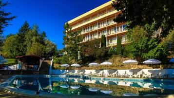 Ein Hotel mit Pool, Liegestühlen und Sonnenschirmen.