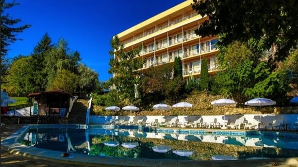 Un hôtel doté d’une piscine, de chaises longues et de parasols.