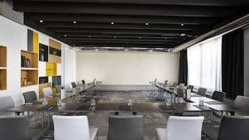 Une salle de conférence moderne, dotée d’une longue table, de nombreuses chaises et d’une palette de couleurs neutres.