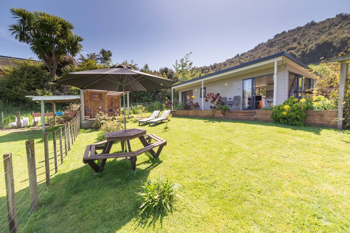 A house with a covered patio, a pool, and a garden.