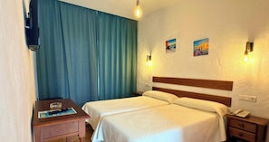 A hotel room with a bed, bedside tables, a desk, and two wall-mounted light fixtures. - Hotel Oasis Atalaya (Conil de la Frontera)