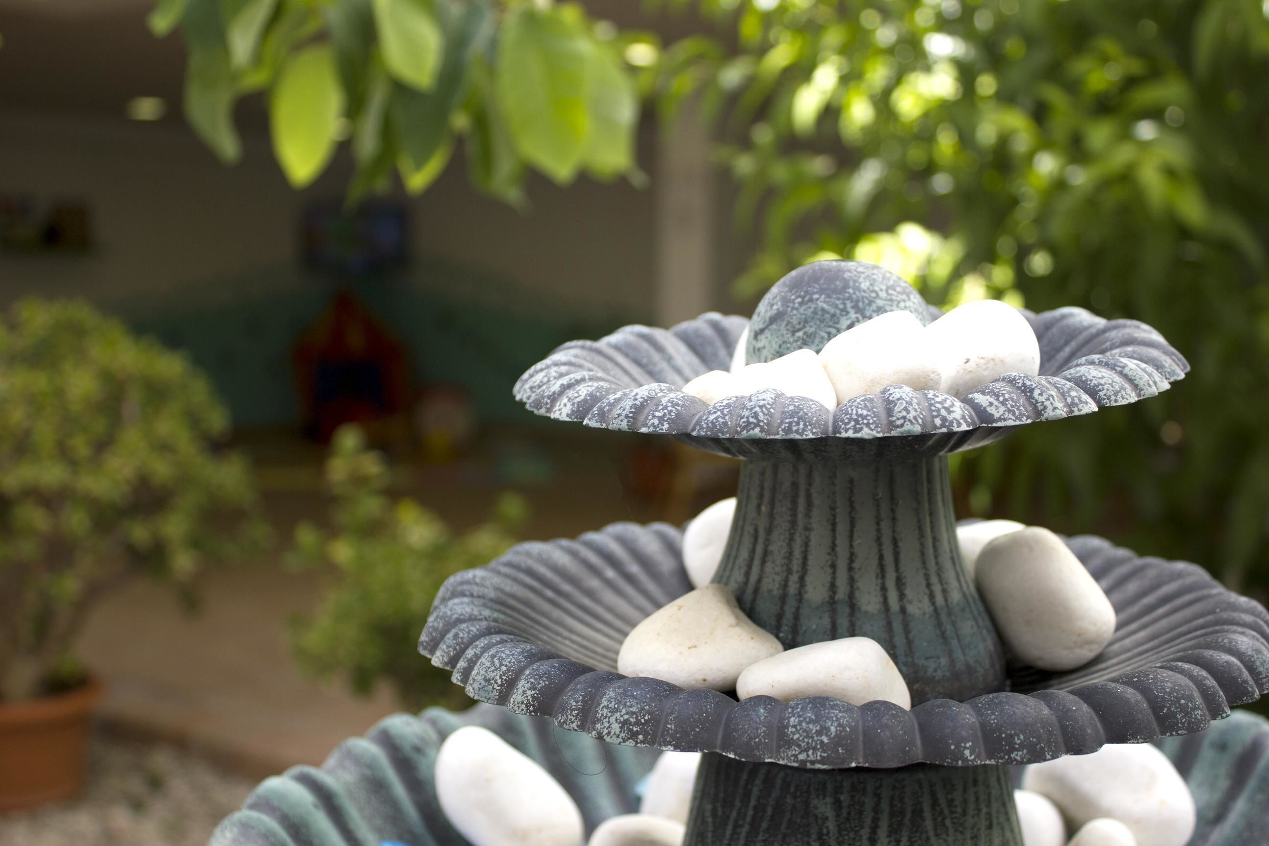 Une fontaine en pierre à plusieurs niveaux, composée de plusieurs étages et de pierres lisses et arrondies.