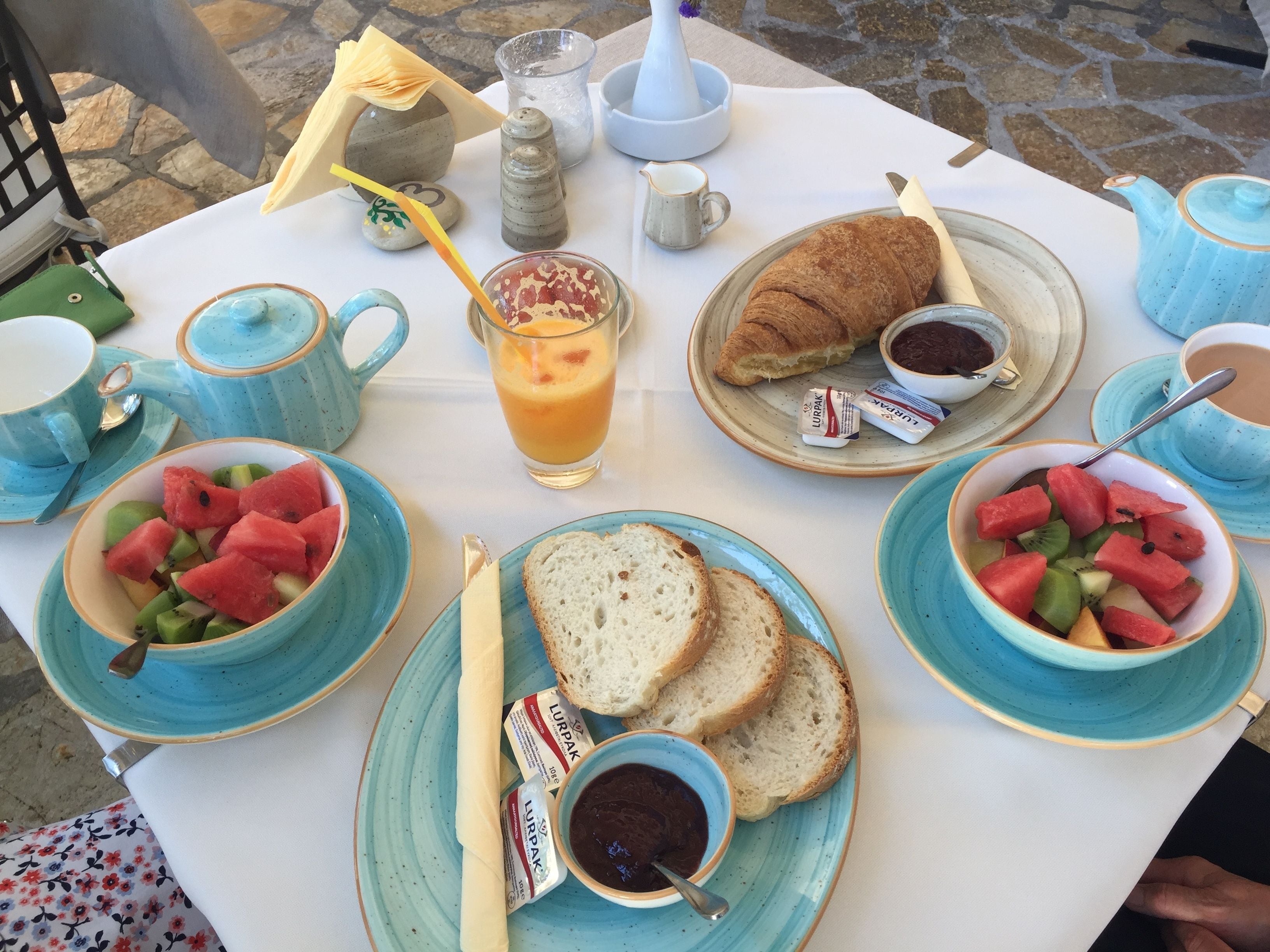 Una tavola imbandita per la colazione, con pane tostato, frutta e salse.