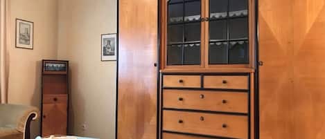 A wooden cabinet with glass doors and multiple drawers.