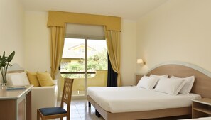A hotel room with a bed, a desk, a chair, and a window with curtains.
