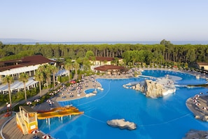A resort with a large swimming pool, palm trees, and a view of the ocean. - Falkensteiner Club Funimation Garden Calabria - All inclusive (Curinga)