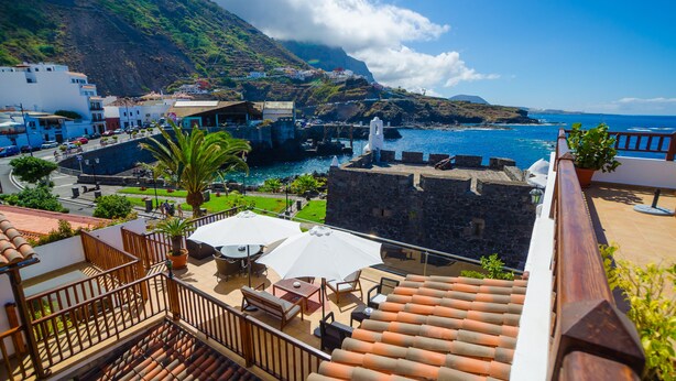 A coastal town with terracotta-tiled rooftops, outdoor seating, and a view of the sea. - Garahotel (Garachico)