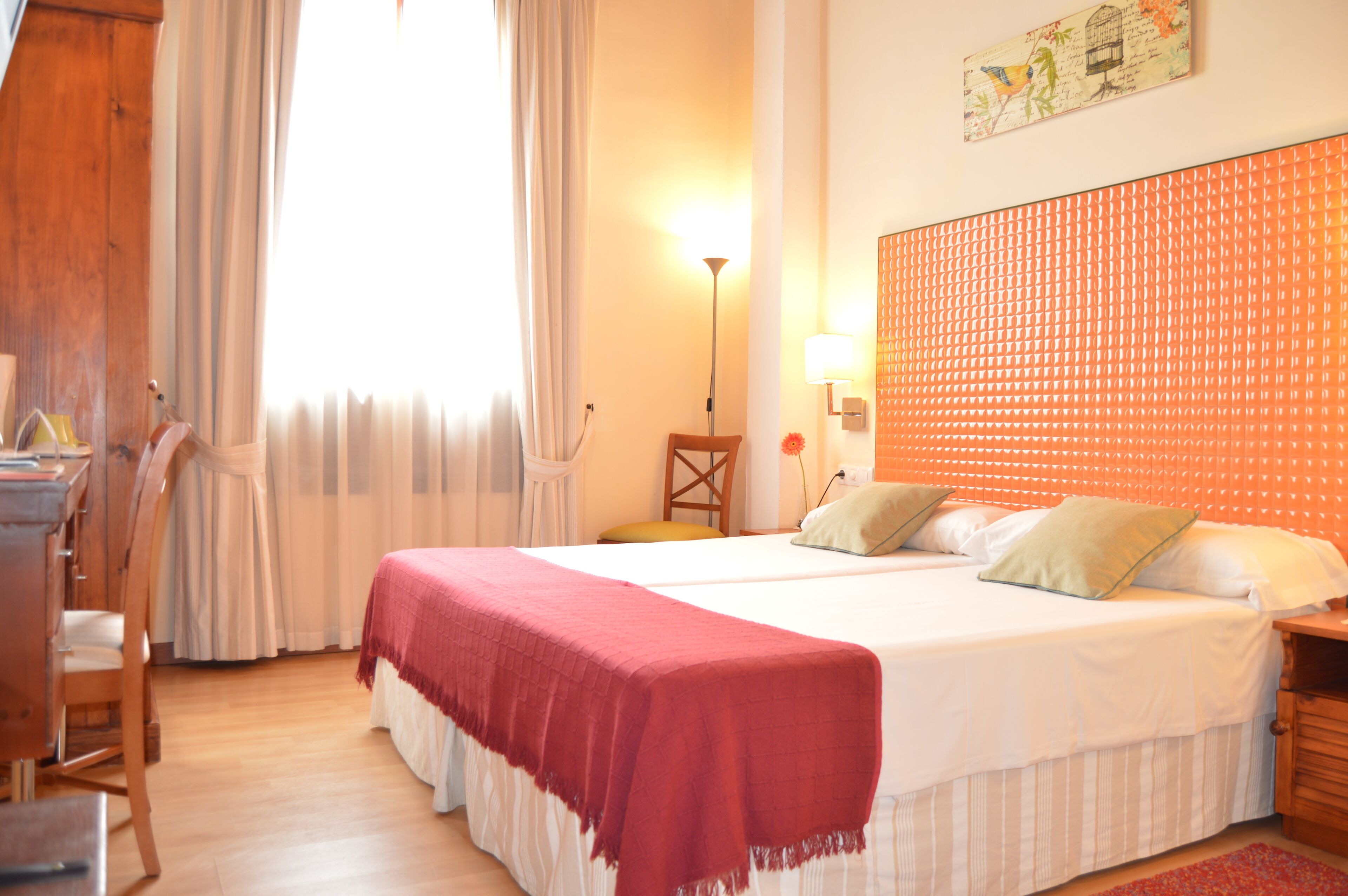 Een hotelkamer met een groot bed, een bureau en een stoel.