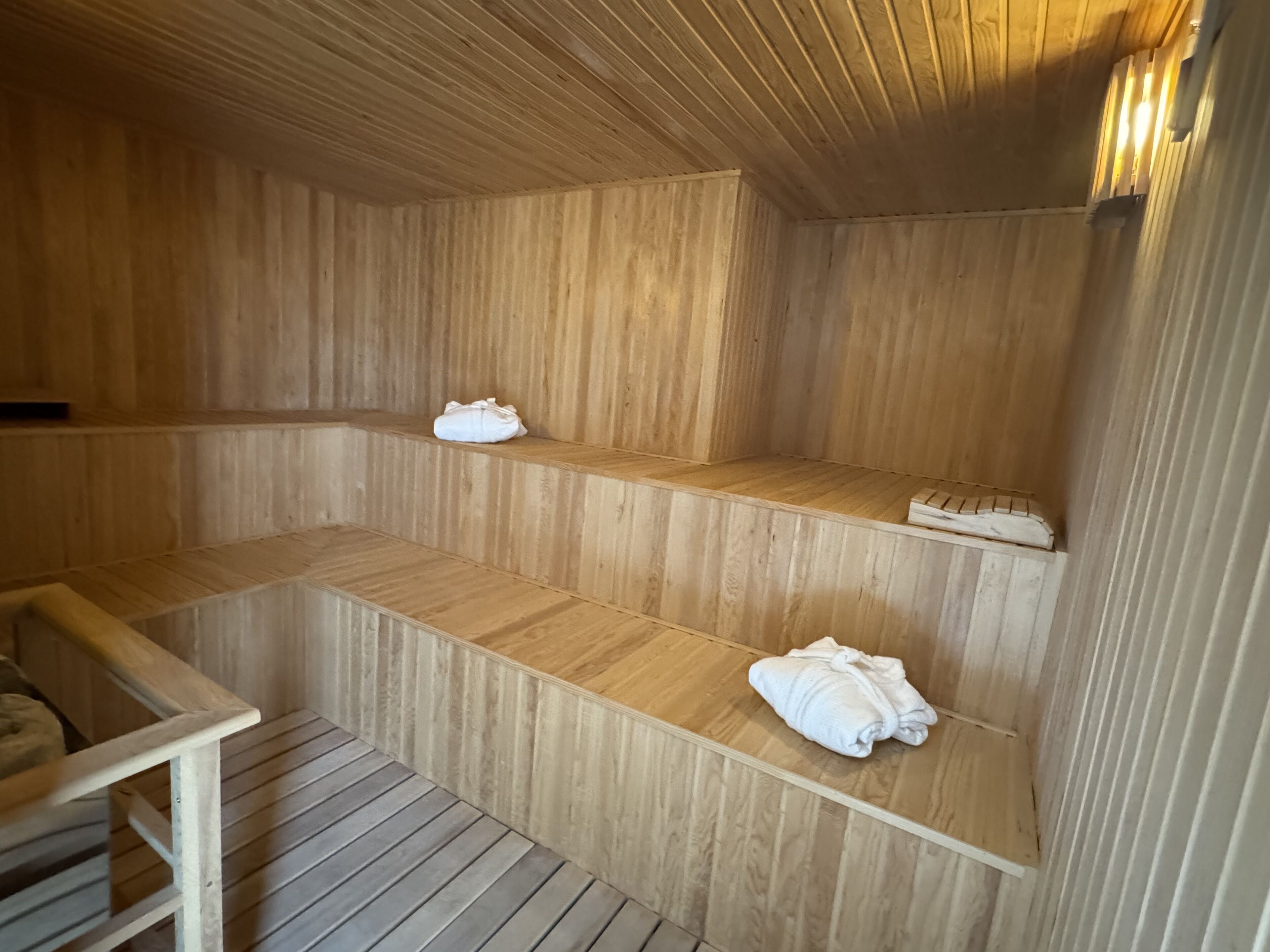 Una sauna in legno con panche e asciugamani.