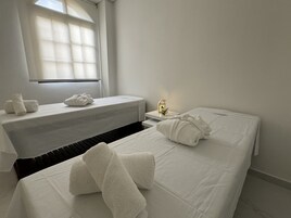 Una habitación de hotel con cama, una banca y una mesita de noche con lámpara.