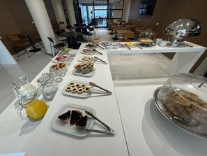A buffet setup with various food items and utensils.